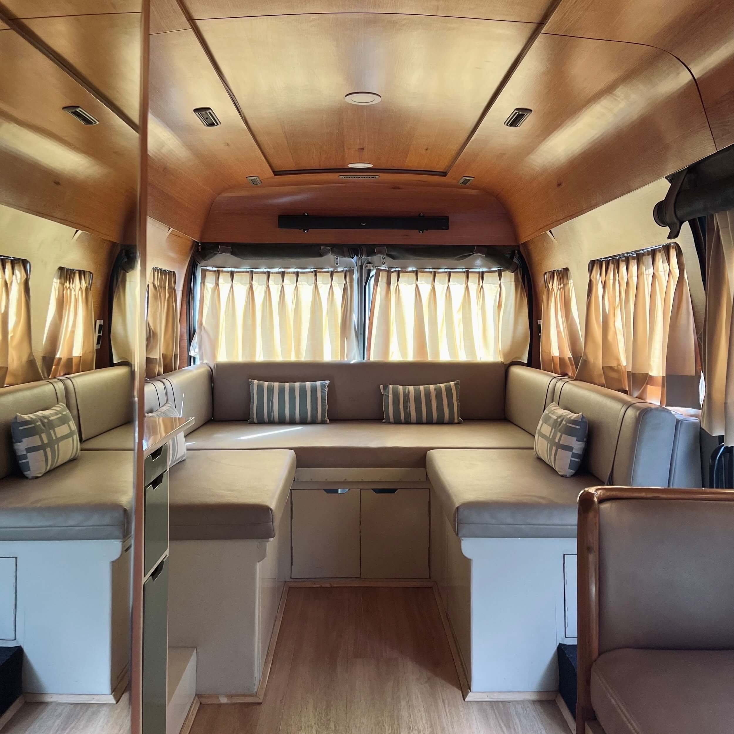 Interior of the Roller campervan showing its teakwood-finished lounge
