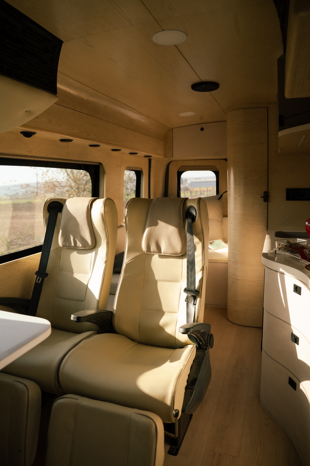 Interior of the Courser caravan in warm cream leather and light oak, built for a multigenerational Jaipur family